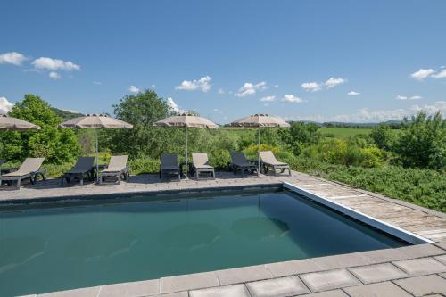 une piscine avec chaises et parasols dans l'établissement Gite Figuier et Vignes, à Saint-Sauveur-de-Cruzières