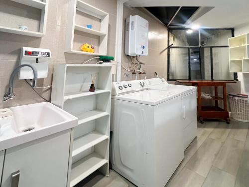 a kitchen with a sink and a washing machine at Sky Loft 3 cuadras a la UTPL 5min del centro in Loja