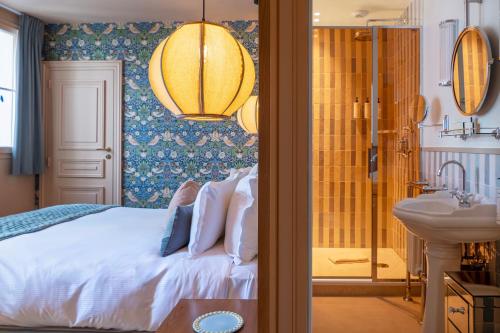a bedroom with a bed and a sink and a mirror at Maison La Bohème Montmartre - Studios & Apartments in Paris