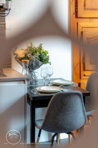 une table avec deux chaises et un vase de fleurs dans l'établissement Les Arcades WiFi Historic Center, à Chambéry