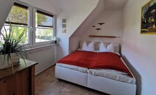 ein Schlafzimmer mit einem Bett mit einer roten Decke in der Unterkunft Sünnenkringel in Zingst