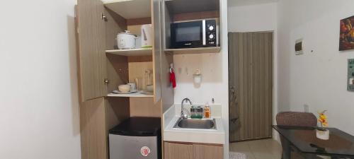 a small kitchen with a sink and a microwave at JJMC HOMESTAY 22 With netflix and fast wifi in Manila