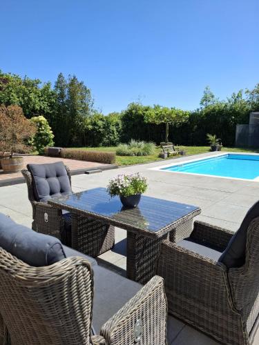 a patio with a table and chairs and a pool at Bed and Breakfast Goeree Overflakkee in Sommelsdijk
