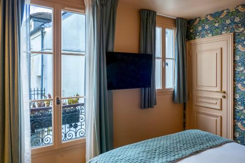 a bedroom with a bed and a window at Maison La Bohème Montmartre - Studios & Apartments in Paris