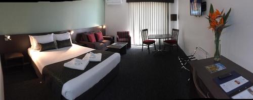 a hotel room with a bed and a living room at Hunts Hotel Liverpool in Liverpool