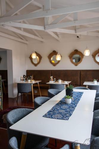 a dining room with a white table and chairs at The Rez Guesthouse in Walvis Bay