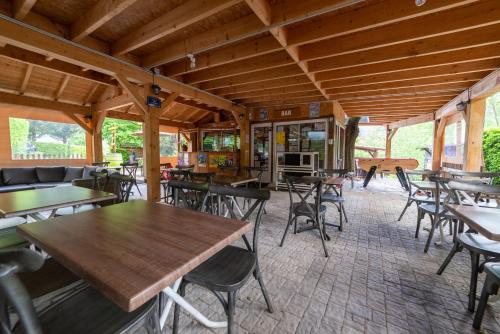 Un restaurante con mesas y sillas en una sala. en Camping Le Barutel, en Meyras