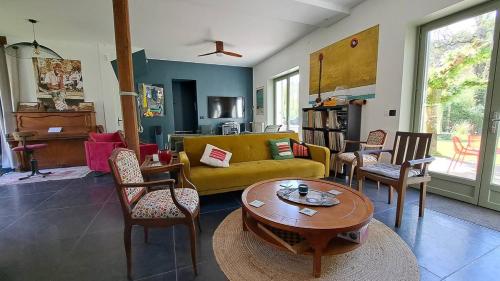 d'un salon avec un canapé et des fauteuils jaunes. dans l'établissement Le Quai de Mezos, à Mézos