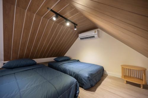 a bedroom with two beds and a wooden ceiling at Morya House in Bangkok