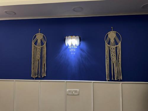 a blue wall with curtains and a light on it at Greece vibes Spacious flat, private, cozy space in Delhi and NCR in New Delhi