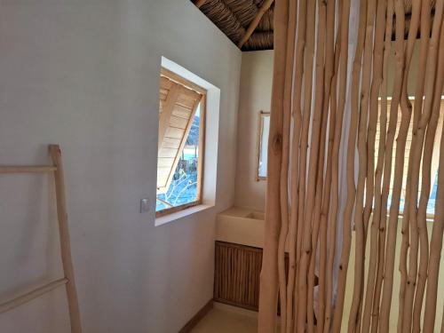 a room with a window and a wooden wall at Beheloka Lodge in Ambalaviro