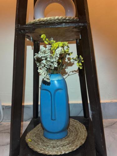 a blue vase with flowers in it on a table at Greece vibes Spacious flat, private, cozy space in Delhi and NCR in New Delhi