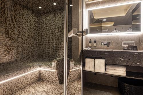 a bathroom with a shower with a glass door at B Montmartre in Paris