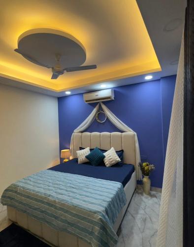 a blue bedroom with a bed with a ceiling at Greece vibes Spacious flat, private, cozy space in Delhi and NCR in New Delhi