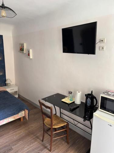 Cette petite chambre dispose d'une table et d'une télévision murale. dans l'établissement Petite chambre indépendante, parking, à Gevrey-Chambertin