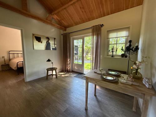a living room with a table and a bedroom at Het plekje dat niemand wist in Ederveen