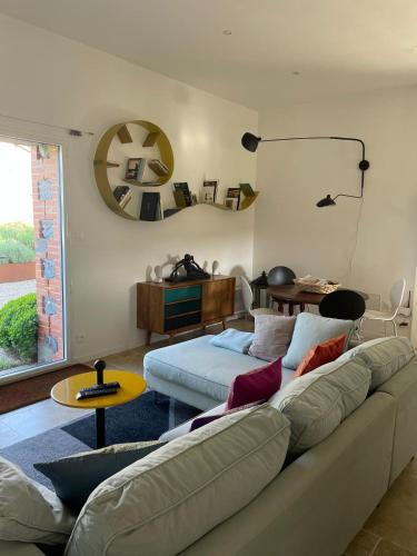 un salon avec un canapé et une table dans l'établissement Au coeur de la Toscane Angevine, à Chaudefonds-sur-Layon