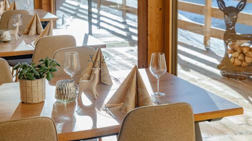 a wooden table with glasses and napkins on it at Lahnerhof Chalets in Lutago