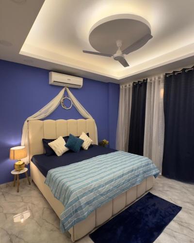 a bedroom with a bed with blue walls and a ceiling at Greece vibes Spacious flat, private, cozy space in Delhi and NCR in New Delhi