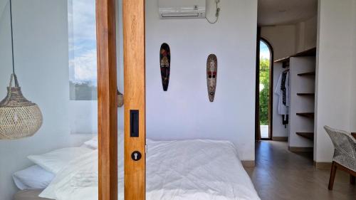 1 dormitorio con cama y tablas de surf en la pared en Stylish New Villa close to the beach, en Uluwatu