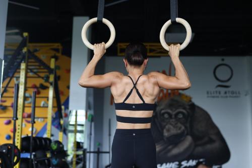 a woman in a bikini is holding up weights at Elite Atoll Serviced Apartments Phuket in Rawai Beach