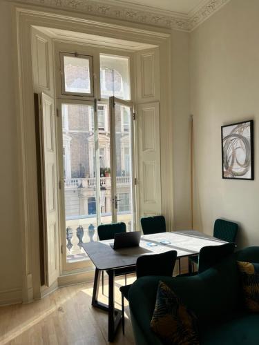 a room with a table and chairs and a window at Newly refurbished- Awesome very central flat in famous Notting Hill with a balcony in London