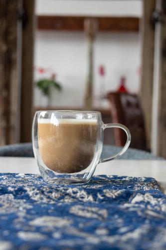 a glass cup of coffee sitting on a table at The Rez Guesthouse in Walvis Bay