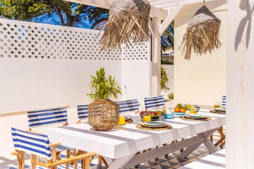 a white table and chairs on a patio at Casa do Cacto - By WeHost in Porto Santo