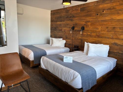 a hotel room with two beds and a chair at Aqua Aire Inn & Suites in Minocqua