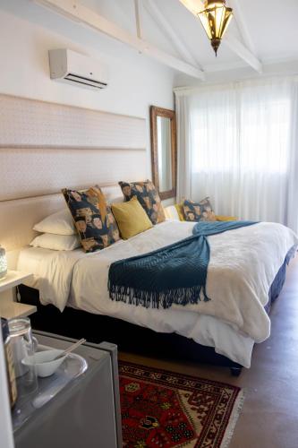 a bedroom with a large bed with pillows on it at The Rez Guesthouse in Walvis Bay