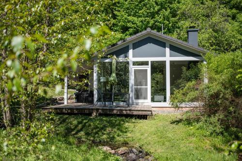 a small cottage with a deck in the woods at 2 bis 4 Personen mit Infrarotsauna F2H9 in Ruhla