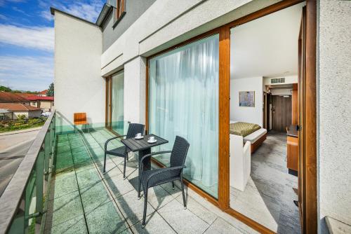 a balcony with a bed and a table and chairs at Wellness Hotel Diamant in Hluboká nad Vltavou