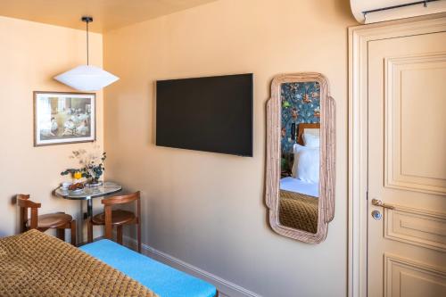 a room with a mirror and a bed and a table at Maison La Bohème Montmartre - Studios & Apartments in Paris
