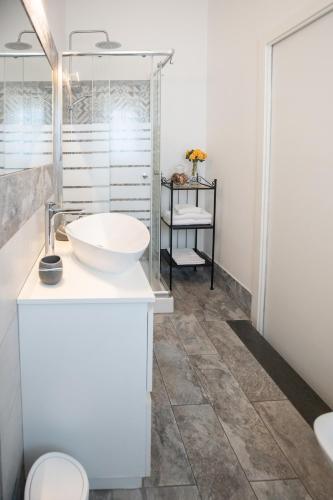 a white bathroom with a sink and a toilet at Catania Over Time - Tourist Rooms in Catania
