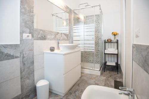 a white bathroom with a sink and a toilet at Catania Over Time - Tourist Rooms in Catania