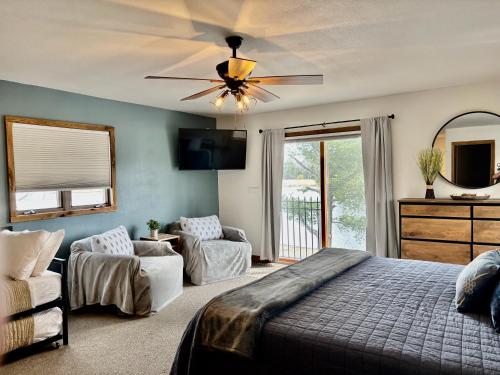 a bedroom with a bed and a ceiling fan at Aqua Aire Inn & Suites in Minocqua