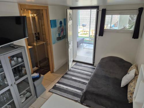 a living room with a couch and a flat screen tv at Au coin tranquille in Champigny-sur-Marne