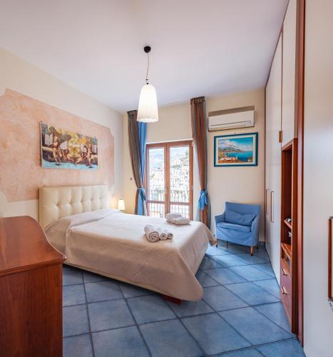 a bedroom with a bed and a blue chair at La casa dei desideri in Maiori