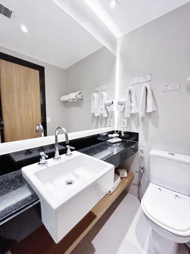 a bathroom with a sink and a toilet and a mirror at Mar Ipanema Hotel in Rio de Janeiro