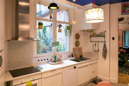 une cuisine avec un évier et une fenêtre dans l'établissement Large Boheme creative flat below Montmartre, à Paris