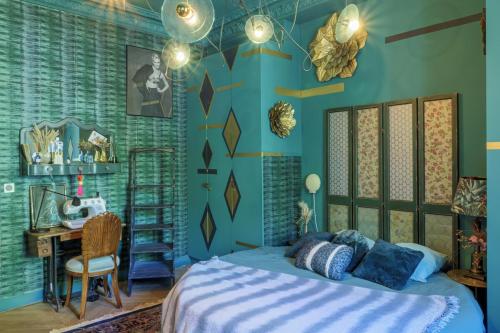 - une chambre avec des murs bleus et un lit avec un bureau dans l'établissement Large Boheme creative flat below Montmartre, à Paris