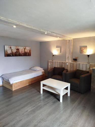 une chambre avec un lit, un canapé et une table dans l'établissement Appartement chez l'habitant, à Granges-Aumontzey