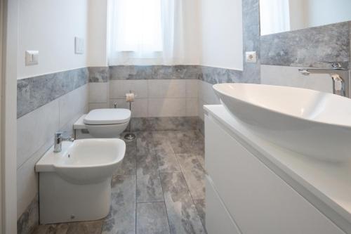 a white bathroom with a sink and a toilet at Catania Over Time - Tourist Rooms in Catania