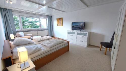 a bedroom with a bed with a television and a chair at Ferienhaus David Nikola in Binz
