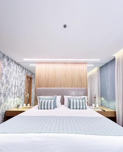 a bedroom with a large white bed with two pillows at Mar Ipanema Hotel in Rio de Janeiro