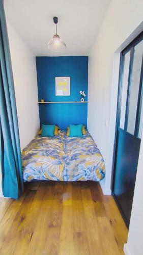 une chambre avec un lit avec une tête de lit bleue dans l'établissement Levalet BNB - La Défense Courbevoie, à Courbevoie