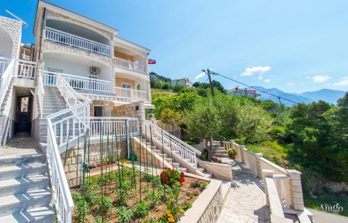 a building with stairs and flowers in a garden at Serenity Apartments in Pisak