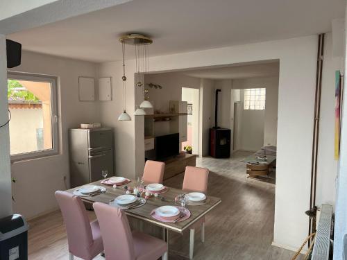 a dining table with pink chairs in a living room at House Dea in Mostar