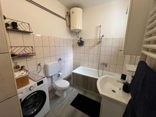 a bathroom with a toilet a sink and a washing machine at House Dea in Mostar