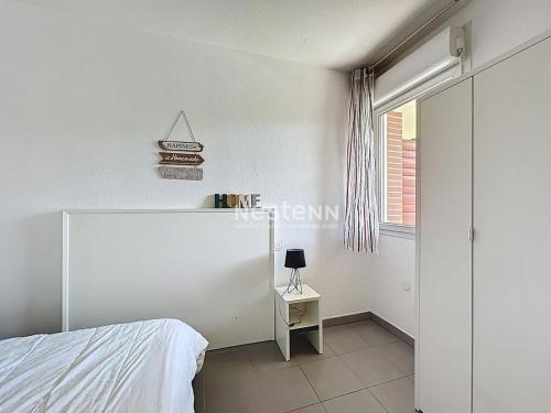 une chambre blanche avec un lit et une fenêtre dans l'établissement 3497-Appartement aux normes handicapés avec Piscine, à Argelès-sur-Mer